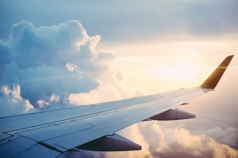 Flugzeugflügel über den Wolken bei Sonnenaufgang – growth pilots B2B Marketing Agentur