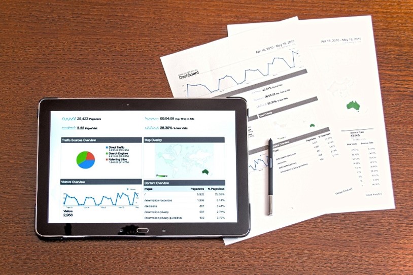 Smart Bidding Tablet und Papiere mit Statistiken und Diagrammen
